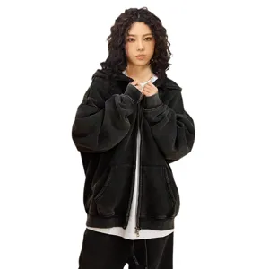 Close-up detail of vintage washed black zip-up hoodie, premium fleece fabric and metal hardware.