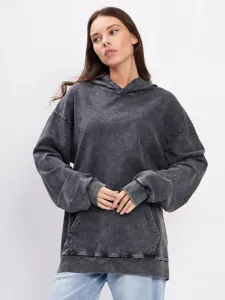Detail view of dark grey vintage washed oversized hoodie with front pocket and ribbed hem.