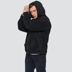 Close-up detail of the heavy black zip-up hoodie, showing texture, zipper, and pocket.