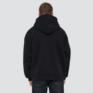 Back view detail of the heavy cotton black hooded sweatshirt with loose casual streetwear fit.