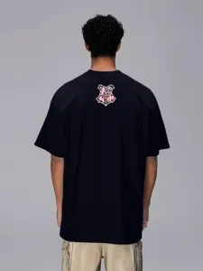 T-shirt nera oversize con stampa grafica sul retro, top streetwear casual per coppie.