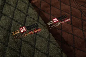 Dettaglio del tessuto della giacca imbottita invernale e ricamo in stile retro di qualità.