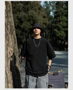 Outdoor model detail shot of the heavy cotton oversized drop-shoulder black t-shirt.