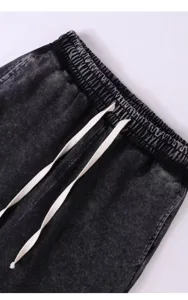Close-up detail of vintage washed distressed apparel elastic waistband with drawstring.