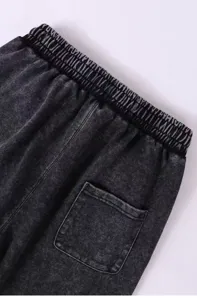 Detailed view of dark grey washed casual pants featuring elastic waistband and back pocket.