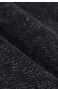 Close up view of dark gray heavy washed fabric showing detailed texture and retro style quality.