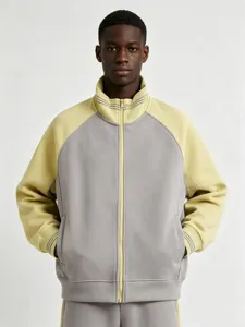 Close up detail of the color blocked zip up track jacket showing ribbed collar and cuffs.