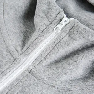 Close-up detail of grey hoodie zipper and knit fabric texture, casual fashion style clothing.