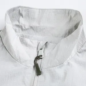 Close up detail of light grey stand collar jacket with zipper and ripstop grid texture.