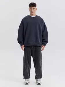 Detalle de sudadera lisa oversize con cuello redondo y ajuste cómodo y relajado.
