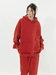 Vue détaillée du sweat à capuche oversize rouge délavé montrant la texture premium.
