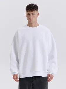 Primer plano detallado de la sudadera blanca lisa con cuello redondo y ajuste holgado.