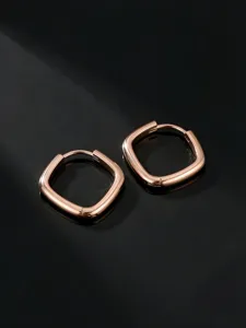 Detailaufnahme minimalistischer roségoldener quadratischer Creolen, elegantes Metalldesign.