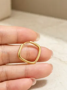 Nahaufnahme Detail minimalistischer geometrischer quadratischer Gold-Creolen mit Politur.