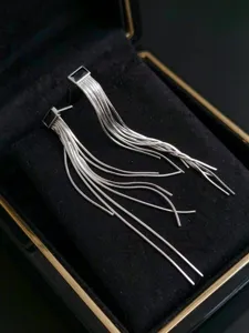 Nahaufnahme Detail von Sterlingsilber Schlangenkette Quaste Ohrringen mit schwarzem Stein.