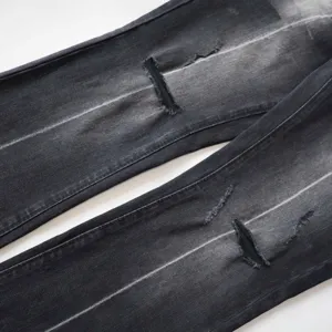 Dettaglio di jeans a zampa retrò da donna con strappi alle ginocchia e sfumature.