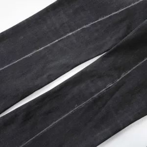 Dettaglio ravvicinato della trama lavata su jeans svasati vintage neri elasticizzati