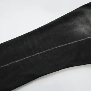 Primo piano ravvicinato della texture del denim nero retrò con piega sbiadita