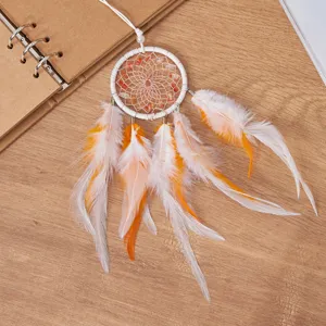 Detailed view of a handmade dreamcatcher car pendant with vibrant orange feathers and stones
