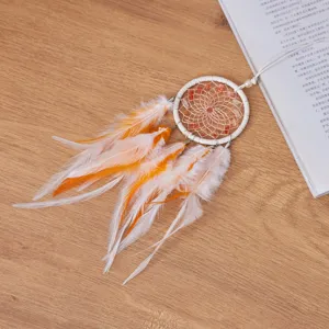 Close-up of handmade dream catcher car pendant with orange feathers