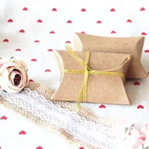 Elegant brown kraft paper wedding candy pillow boxes with decorative gold glitter ribbon