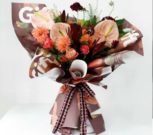 Detail shot of waterproof floral wrapping paper with elegant gift print and plaid ribbon accent.