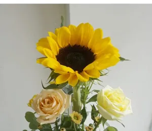 Nahaufnahme der frischen Blumenarrangements mit Sonnenblume und Rosen als Dekoration.