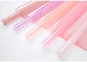 Detailed view of colorful transparent cellophane wrapping paper rolls in pastel pink and purple.