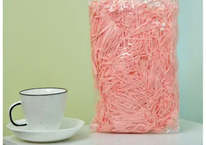 Pink shredded paper filler for gift boxes, raffia paper shred packaging material for presents.