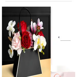 Zwarte trapeze handtas bloemendoos met kunstmatige rozen en orchideeën voor cadeauverpakking.