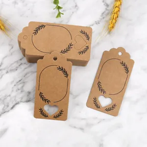 Kraft paper gift tags with heart cutouts and leaf prints for party decorations detail shot