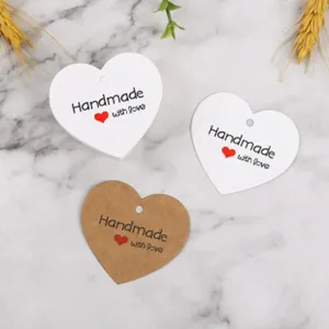 Heart-shaped paper gift tags for Valentine's day, handmade craft labels with string holes.
