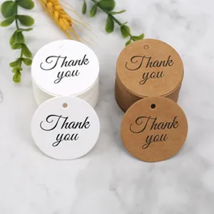Detailed view of round kraft paper and white gift tags printed with elegant thank you text.