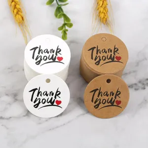 Round paper thank you tags detail view, kraft and white gift labels with holes for packaging.