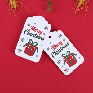 Detailed view of Christmas gift tags with Merry Christmas and gift box prints on red background.