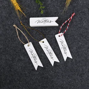Close up of paper gift tags with strings for Mother's Day celebration packaging decor details.