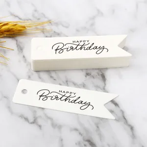 Close-up view of elegant white paper gift tags with black happy birthday typography.