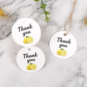 Detailed close-up shot of round paper lemon gift tags featuring thank you print and twine.