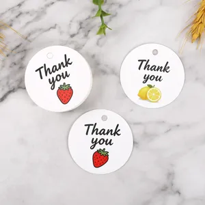 Round paper gift tags with strawberry and lemon prints, thank you labels for packaging.