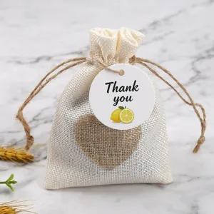 Linen drawstring gift bag with heart patch and lemon thank you tag for wedding party favors.