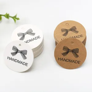 Close-up detail of round paper hang tags with cute bow and handmade text for gift decoration.