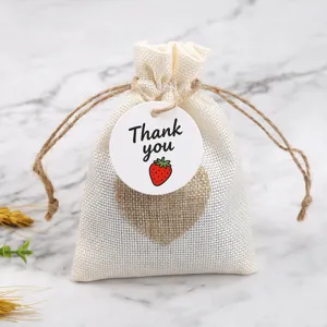 Burlap drawstring gift bag detail showing heart patch and cute strawberry thank you tag.