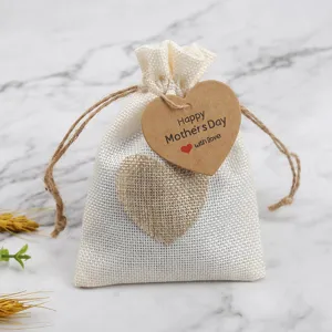 Close-up detail of white burlap gift pouch with heart tag and text design for gift decor.