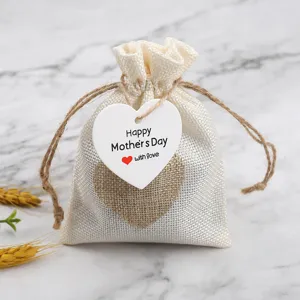 Details of Mother's Day burlap gift bag with heart tag and linen decoration, close up view.