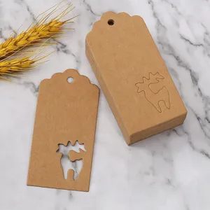 Close-up detail of hollow-out reindeer kraft paper Christmas gift tags on marble background.