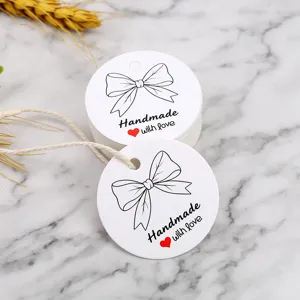 Round white paper gift tags with black bow and handmade with love print for baking and gifts.