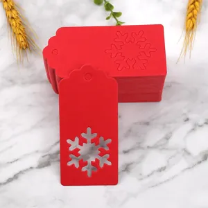 Red paper Christmas gift tags featuring intricate snowflake cutouts, perfect for holiday packaging.