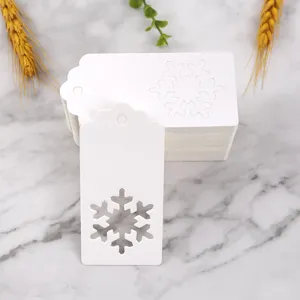 White paper gift tags with hollow snowflake design, perfect for Christmas packaging and crafts.