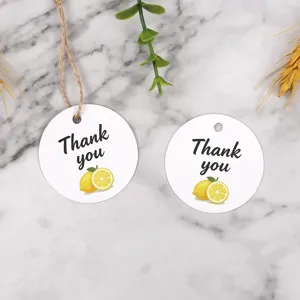 Round paper gift tags with lemon print and thank you text for packaging and decor.