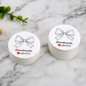 Round white paper gift tags with bow design, perfect for handmade baking packaging details.